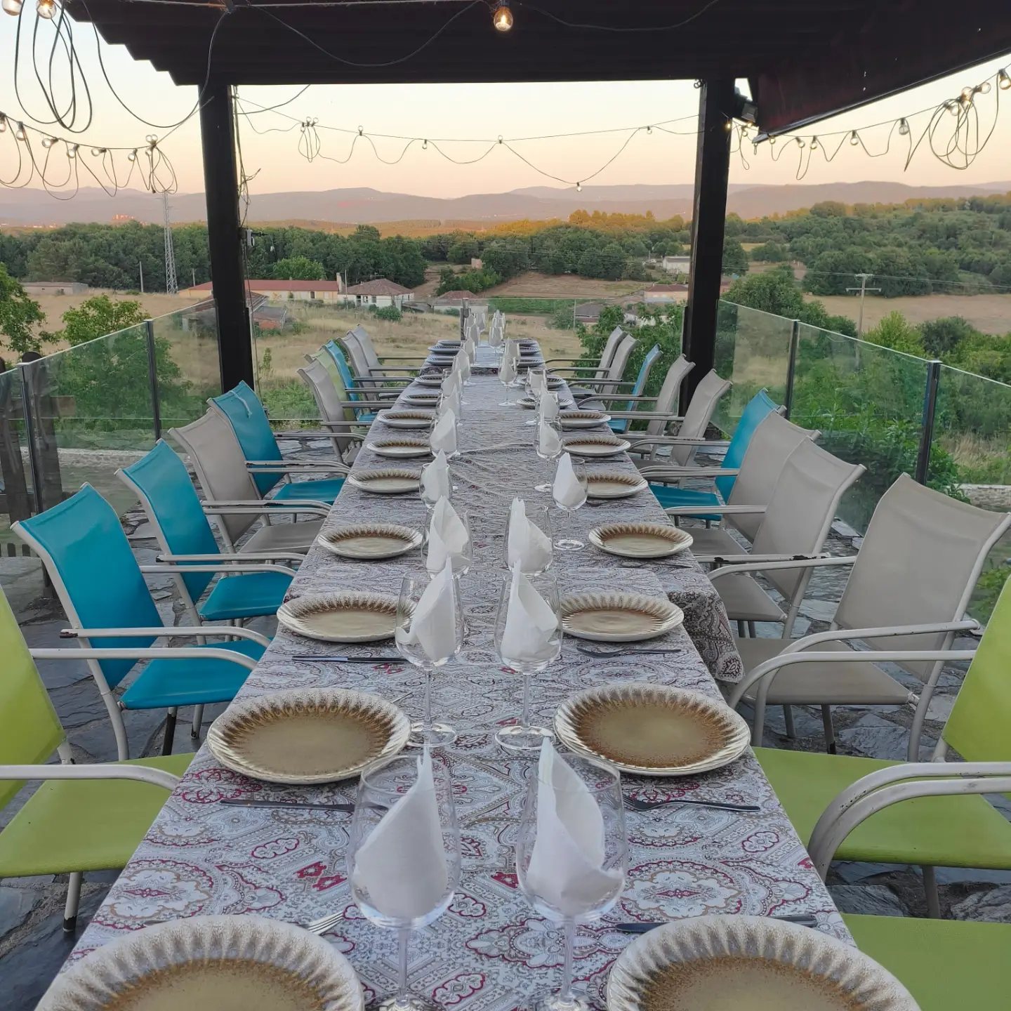 Mesa larga preparada en la terraza de Casa dos Muros al atardecer